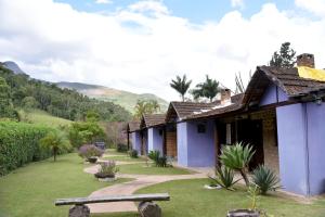 a row of houses with a bench in a yard at Pousada Vale da Mata in Pedra Azul