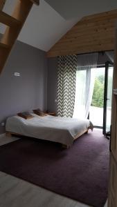 a bedroom with a bed and a large window at Marzeniec pokoje Wapienne w Beskidzie Niskim in Wapienne