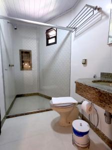 a bathroom with a shower and a toilet and a sink at Pousada Vale da Mata in Pedra Azul