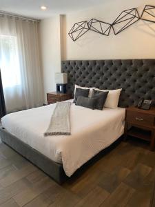 a bedroom with a large bed with a large headboard at Suites Rio Elba in Mexico City