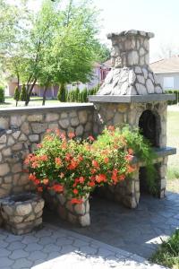 a stone wall with flowers and a stone fountain at Sobe Alex in Veliko Gradište