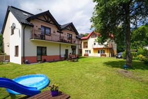 a yard with a house and a blue slide at Maximo - 50m from the Beach in Darlowko