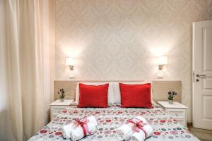 um quarto com uma cama com almofadas vermelhas em Marta Inn em Roma