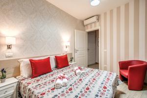 um quarto com uma cama com almofadas vermelhas e uma cadeira vermelha em Marta Inn em Roma