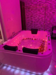 a pink bath tub in a room with lights at Al Hreer Hotel in Hafr Al-Batin