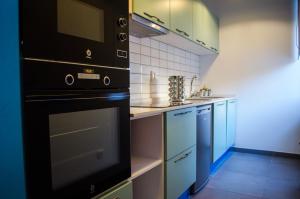 a small kitchen with a stove and a sink at Casa da Guarda in São João