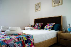 ein Schlafzimmer mit einem Bett und einer bunten Decke in der Unterkunft Casa da Guarda in São João