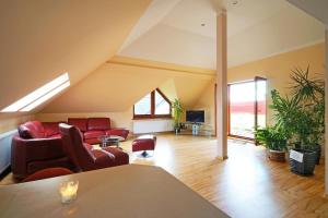 a living room with red chairs and a couch at Maximo - 50m from the Beach in Darlowko