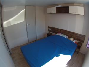 Habitación pequeña con cama azul. en La Carabasse / Mazet 69, en Vias