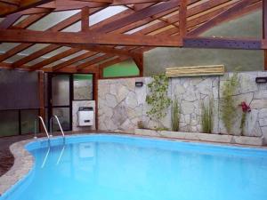 a large swimming pool in a building with a wooden ceiling at Cabañas Arique in San Martín de los Andes +21 photos