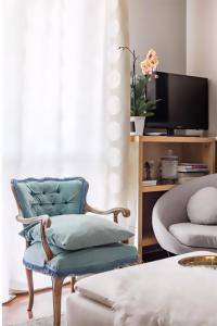 un soggiorno con sedia blu e TV di Golden Suite apartment & day use a Milano