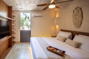 a bedroom with a bed with a television and a bowl of food at Kiki Tulum in Tulum