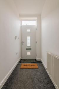 a door with a welcome mat on the floor in a room at Fantastic brand new Rooms in Bury