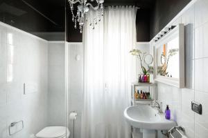 un bagno con lavandino, servizi igienici e lampadario pendente di Golden Suite apartment & day use a Milano