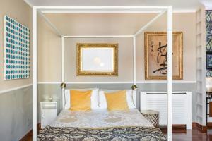 una camera da letto con letto a baldacchino bianco e cuscini arancioni di Golden Suite apartment & day use a Milano
