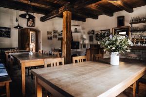 een restaurant met houten tafels, stoelen en bloemen bij Ábelův mlýn in Turnov