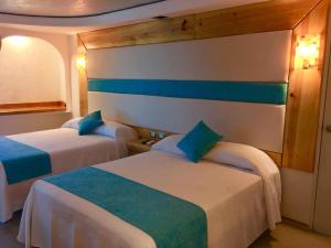 カンクンにあるHotel Blue Star Cancunの青と白のベッド2台が備わる客室です。