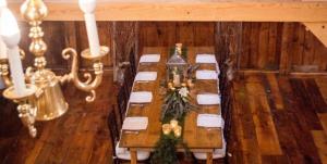 a dining room with a long table with white chairs at Highland Lake Inn in Andover