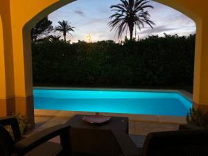a swimming pool with a view of a sunset at Victoria's Dream in Cala en Blanes