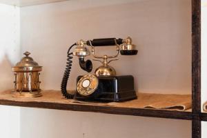 an old fashioned phone on a shelf with a tea kettle at Villa Takaosan in Hachioji