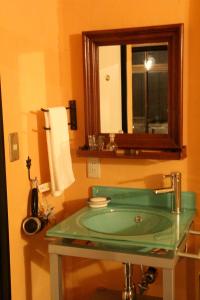 ein Badezimmer mit einem grünen Waschbecken und einem Spiegel in der Unterkunft Villa Takaosan in Hachioji