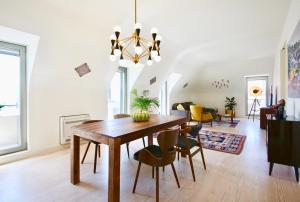 a dining room and living room with a wooden table and chairs at Luxury Apartment by MyPlaceForYou, very quiet, close to Time Out Market Lisbon in Lisbon