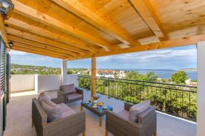 eine Terrasse mit Stühlen und einem Tisch auf dem Balkon in der Unterkunft Villa Dupla Kanica in Sevid