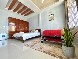 a living room with a red couch and a bed at Hue Lovely Homestay in Hue +69 photos