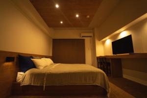 a bedroom with a bed and a flat screen tv at HIT Tenjin in Fukuoka