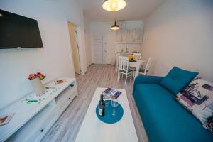 a living room with a blue couch and a table at Apartmani Stari Grad in Sutomore
