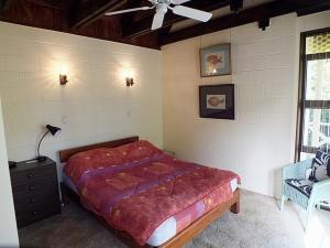 Un dormitorio con una cama y un ventilador de techo. en Wharepekapeka - Russell Holiday Home, en Russell