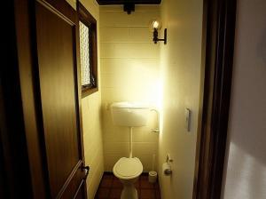 Un pequeño baño con inodoro y ventana. en Wharepekapeka - Russell Holiday Home, en Russell 7 fotos más