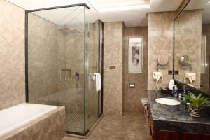 a bathroom with a shower and a tub and a sink at GuangZhou TongYu International Hotel in Guangzhou