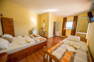 a bedroom with two beds and a television at Apartmani Stari Grad in Sutomore