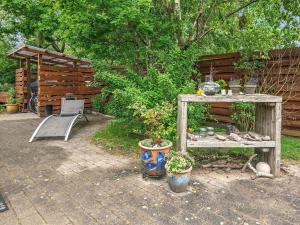 a garden with a table and a bench and plants at 5 person holiday home in Middelfart in Middelfart