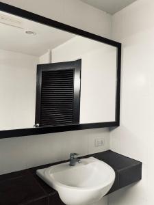 ein Badezimmer mit einem weißen Waschbecken und einem Spiegel in der Unterkunft J Hotel in Ao Nang Beach