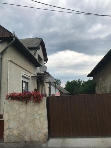 une maison avec une clôture et des fleurs sur elle dans l'établissement Nyugalom Pihenő, à Kisújszállás