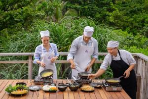 a group of three chefs preparing food on a grill at Six Senses Con Dao - Turtle Island Paradise in Con Dao
