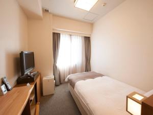 Un pat sau paturi într-o cameră la Dormy Inn Tsu