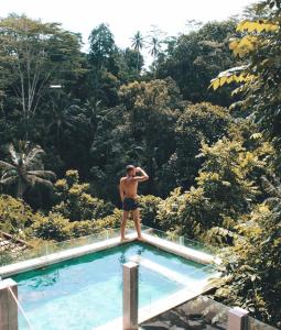 un homme debout au bord d'une piscine dans l'établissement Ubud Hills Villas & Resort, à Ubud