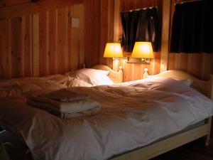 出雲市にある一畑山コテージのランプ2つが備わる客室の大きな白いベッド1台