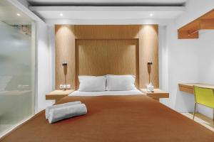 ein Schlafzimmer mit einem großen Bett und einem gelben Stuhl in der Unterkunft Skyland Bogor Valley Apartments in Bogor