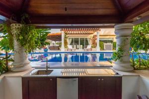 a kitchen with a sink and a swimming pool at Villa Lazuli - Saadiyat Island - A one-of-a-kind stay, with jacuzzi and pool - limited to 12 in Abu Dhabi