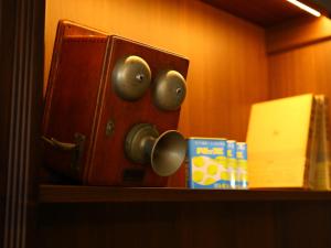 a wooden cabinet with knobs and a box on a shelf at KOKO HOTEL Ikebukuro in Tokyo