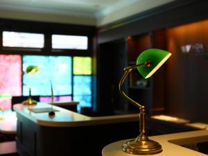 Hotel Wing International Select Ikebukuro في طوكيو: وجود مصباح أخضر على طاولة في الغرفة