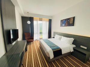 a hotel room with a bed and a television at Bahang Bay Hotel in Batu Ferringhi