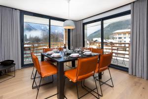 a dining room with a table and chairs and windows at La Cordee 612 apartment- Chamonix All Year in Chamonix-Mont-Blanc