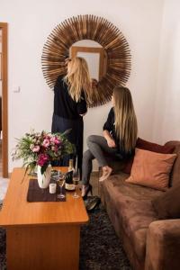 a woman standing in a living room in front of a mirror at Apartmány Kolonáda in Luhačovice