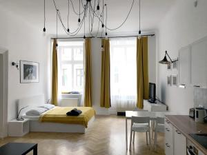 um quarto com uma cama, uma mesa e uma cozinha em Florianska Apartment em Cracóvia