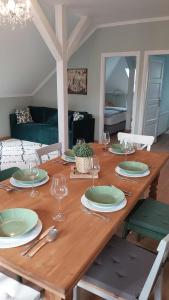 a wooden table with plates and wine glasses on it at A Zoldbiciklis Haz in Egerszalók